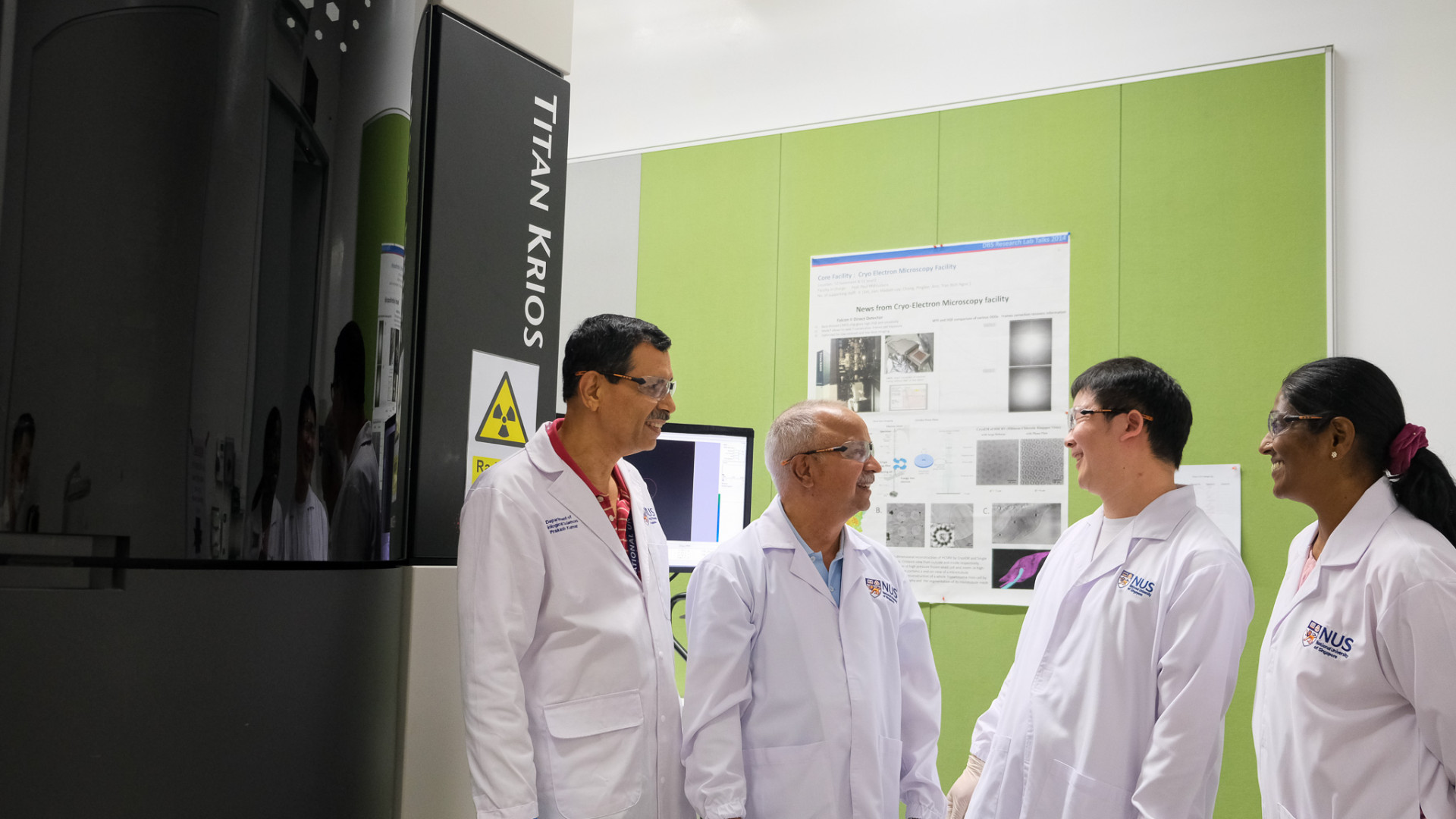 Members of the research team next to the Titan Krios, a state-of-the-art cryogenic transmission electron microscope in NUS. The microscope enabled the team to visualise and understand how the self-assembled foldamers are inserted into lipid bilayers.